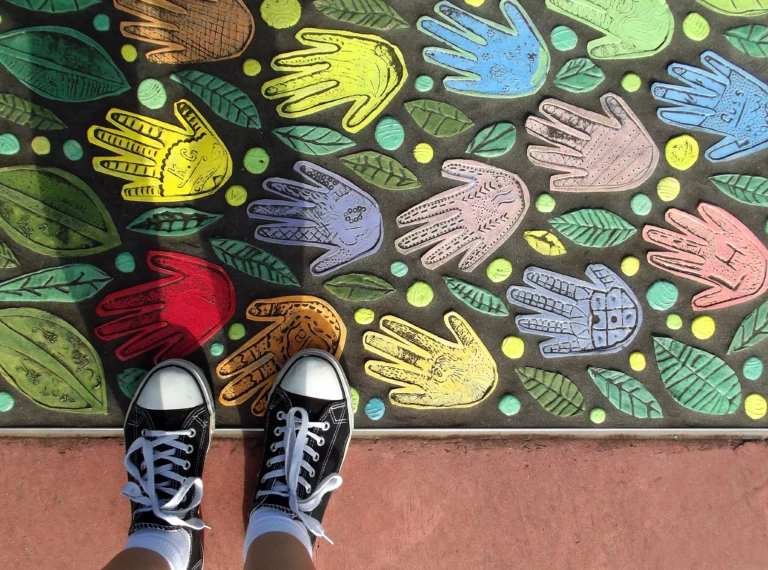 AnyConv.com__shoes-standing-on-a-mosaic-of-painted-hands-2026-01-07-00-22-48-utc